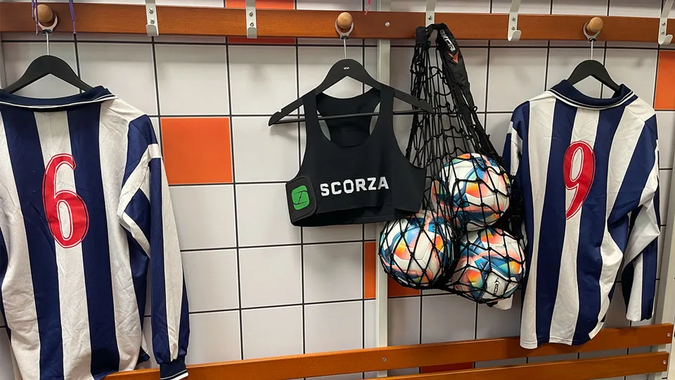A changing room with team shirts and Scorza vests hung up ready for kick-off