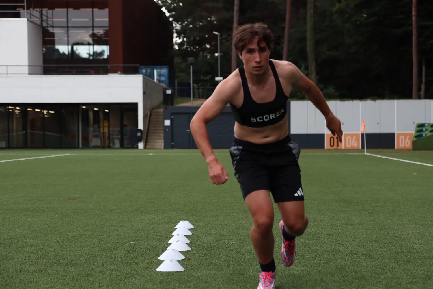 Player sprinting through cones in a Scorza vest during a fitness session